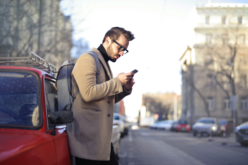 Distracted user Man on the street looking at his smartphone